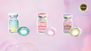 Three vials with blue-green, pink, and hazel colored contacts on a pastel pink background.