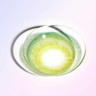 Macro shot of a green contact lens color, showing the dotted and striated pattern designed to transition seamlessly onto an iris, on a light background