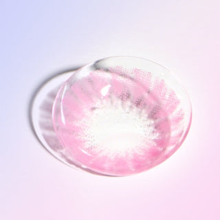 Macro shot of a pink contact lens, showing the radial pattern designed to lighten and brighten eyes, on a light background