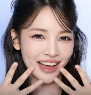 Model with natural makeup and long lashes wearing EyeCandys i-Sha Dekame Kiss Me 1-Day Blue Pop colored contact lenses