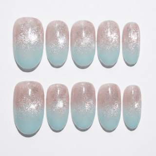 Mist n Fade Press-On Nails by EyeCandys: a set of 10 handmade nails with a soft pink-to-light blue ombre, finished with silver glitter for a salon gel manicure look, neatly arranged in two rows on a white background.