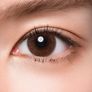 Model's eye wearing the Acuvue Sheer Dream color contact lens with light eye makeup, showing the widening effect of the circle lens on a dark iris.