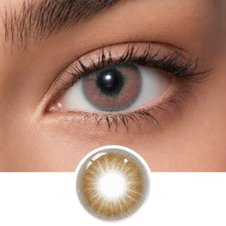 A close-up of a personโs eye wearing EyeCandys Aura Brown Grey contacts, with a detailed lens image below. The design features a golden-brown pattern, clear pupil center, and provides UV protection.