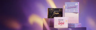 EyeCandys contact lens boxes in Bunnie, Doe, Desire, and Cashmere designs arranged against a dreamy purple backdrop with warm diagonal lighting.