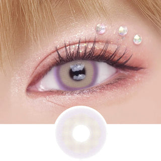 Pink Label Mykonos Violet color contact lens on top of a dark eye paired with peach shimmering eye makeup and curled wispy eyelashes, above the contact lens design.