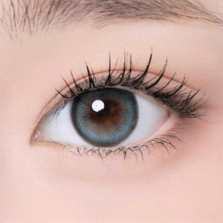 One Pick Becca Matcha color contact lens on top of a dark eye paired with subtle eye makeup and curled wispy eyelashes