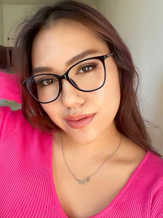 Model wearing the Billionaire Oval back, blue light blocking glasses on top of brown coloured contact lenses