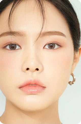 Asian model demonstrating a K-idol-inspired look with Chuu Cloud Pudding Grey (10pk) coloured contact lenses, highlighting the instant brightening and enlarging effect of the circle contact lenses over dark irises.