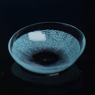 Macro shot of the EyeCandys Dare to be blue prescription colored contact lens on a dark background, showing the detailed pattern of the contact lens design