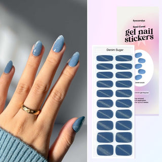 Hand showcasing EyeCandys Denim Sugar Gel Nail Stickers in blue with glitter accents. Trendy spring nails with a 7-free, allergy-friendly formula that lasts 2-3 weeks. Cures in sunlight, no UV lamp needed, for a vibrant, sparkling nail look.