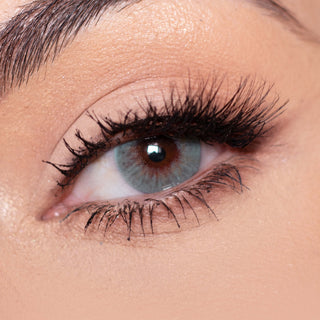 Close-up shot of a model with natural dark eyes wearing Dewy Aqua color contact lenses, complemented by natural eye make up. Close-up image showcases the model's eyes adorned with the same blue contact lenses. 