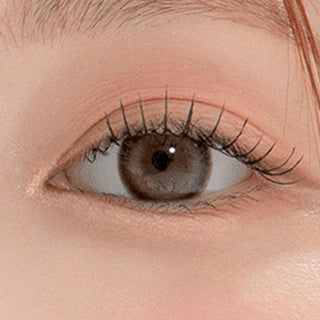 Macro shot of an eye wearing the DooNoon Bono Cheese Grey prescription colour contact lens, showing the multi-colored detail and natural effect on dark brown eyes.