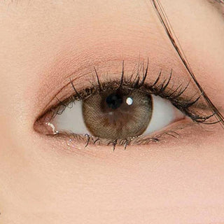 Macro shot of an eye wearing the DooNoon Glam 1-Day Grey (10pk) prescription colour contact lens, showing the multi-colored detail and natural effect on dark brown eyes.