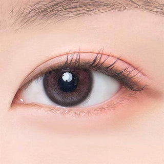 Macro shot of an eye wearing the DooNoon Jinju Shell 1-Day Burgundy (10pk) prescription colour contact lens, showing the multi-colored detail and natural effect on dark brown eyes.