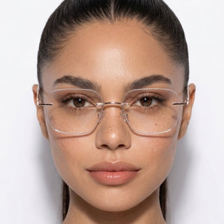 A woman with straight dark hair pulled back wears EyeCandys Dusk Rimless Rectangular Glasses, looking directly at the camera with a neutral expression against a plain white background.
