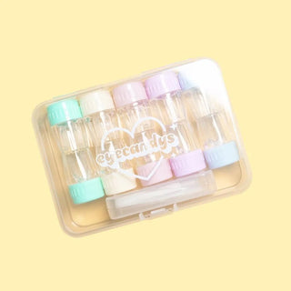 The EyeCandys Cotton Candy Colored Contact Lens Case Travel Kit features six pastel lens containers with pink, purple, green, blue, and white caps in a clear case labeled "EyeCandys," shown on a pale yellow background with a heart design.