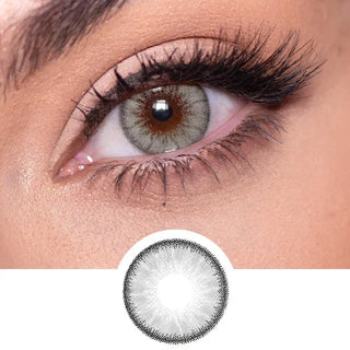 Close-up shot of a model eye wearing Desire Mist Grey colored contact lens in one eye that is naturally dark-brown with natural rosegold eye make up