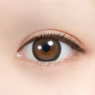 Close-up of an eye wearing Feliamo 1-Day Tarte Tatin prescription colored contact lenses. Warm milk chocolate brown contacts with a bold 3.2mm dark outer ring create a polished, defined circle lens effect. Japanese daily disposable colored contacts that enhance brown eyes with a natural caramel tone, subtle enlargement, and comfortable all-day wear.