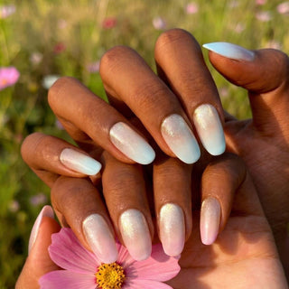 Stylish hand wearing First Light press on nails featuring soft aurora gradient nails with glowing iridescent shimmer effect.