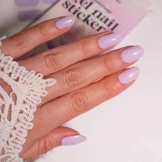 Model's hand showcasing EyeCandys French Lavender Gel Nail Stickers. These soft lavender-colored stickers offer a delicate, elegant look with a glossy finish, providing a long-lasting, chip-free manicure for a sophisticated and fresh touch to your nails.