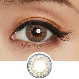 Close-up view of the Pink Label Fresh Look Grey colored contacts for astigmatism on a woman's dark brown eye, paired with matching simple eye makeup, above a cutout of the color contact lens starburst pattern.