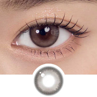Close-up shot of model's eye adorned with Gemhour Melinoe 1-Day Grey Beige daily color contact lenses with prescription, complemented by clean eye makeup, showing the brightening and enlarging effect of the circle contact lens on dark brown eyes, above a cutout of the contact lens pattern with limbal ring on a white background.