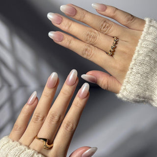 Hand wearing EyeCandys Glazed Donut press on nails featuring soft pink to milky white glazed gradient with glossy clean girl finish.