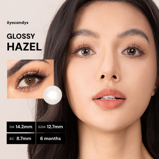 Model with natural makeup wearing EyeCandys Glossy Hazel prescription colored contact lenses - full face and close-up of eyes with long lashes, vibrant natural hazel color, comfortable daily wear, trending cosmetic lenses 2025
