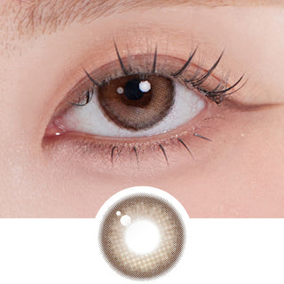 Close-up shot of a model wearing eyesm hugmoon brown prescription colored contact lens in one eye, on top of the contact lens pattern design.