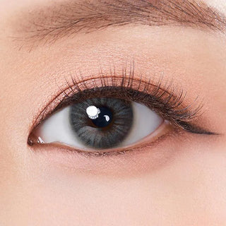 Macro shot of an eye wearing the Olola Heiress Grey (KR) prescription colour contact lens, showing the multi-colored detail and natural effect on dark brown eyes.