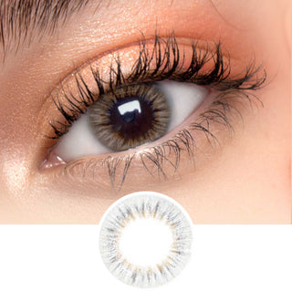 Close-up shot of model's eye adorned with EyeCandys I-Girl Brown daily color contact lenses with prescription, complemented by clean eye makeup, showing the brightening and enlarging effect of the circle contact lens on dark brown eyes, above a cutout of the contact lens pattern with limbal ring on a white background.