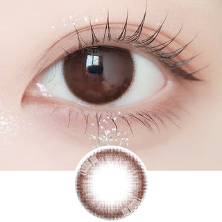 Close-up shot of model's eye adorned with Ann365 JUST 1-Day Choco (10pk) daily color contact lenses with prescription, paired with clean-girl eye makeup, showing the brightening and enlarging effect of the circle contact lens on dark brown eyes, above a cutout of the contact lens with limbal ring on a white background.