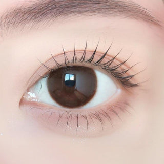 Close-up of model's eye wearing with Ann365 JUST MAX Choco Korean color contact lens with prescription, complemented with barely there eye makeup, showing the brightening and enlarging effect of the circle lens on dark brown eyes.