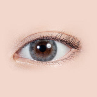 Close-up shot of model's eye adorned with Lilmoon Monthly Rusty Grey (Non Prescription) color contact lenses with prescription, complemented by minimalist eye makeup, showing the brightening and enlarging effect of the circle contact lens on dark brown eyes.