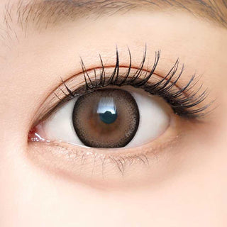 Close-up shot of a model with natural dark eyes wearing Dekame Look At Me Brown contact lenses, complemented by natural eye make up.