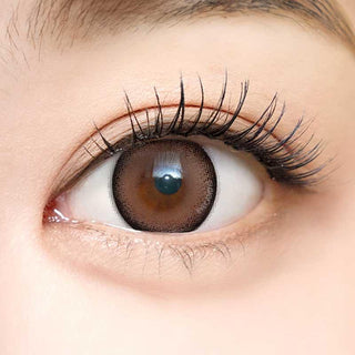 Close-up shot of a model with natural dark eyes wearing Dekame Look At Me Sand contact lenses, complemented by natural eye make up.