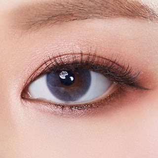 Macro shot of an eye wearing the Olola Mellows Mystic Grey (KR) prescription colour contact lens, showing the multi-colored detail and natural effect on dark brown eyes.