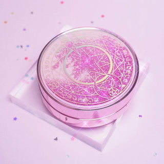 Pink Sailor-Moon themed travel kit case for carrying contact lenses, photographed on a clear acrylic block on a pink background