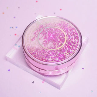 Pink Sailor-Moon themed travel kit case for carrying contact lenses, photographed on a clear acrylic block on a pink background