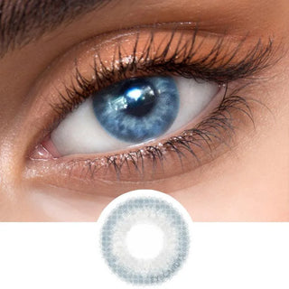 Close-up view of EyeCandys Sugarlook blue contact lens on a model's dark eye, paired with natural eye makeup, above the graphic design of the blue eye contacts.