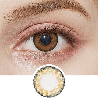 A close-up shows an eye wearing NEO Vision Cosmo Brown lenses by NEO Vision, highlighting the light center and dark outer ring. These circle lenses create a striking look and enhance your natural eye color with their detailed design below.