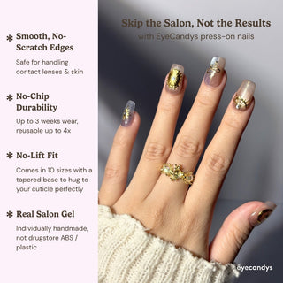 Stylish hand wearing EyeCandys Nyx press on nails with glowing cat eye effect and gold celestial nail art in square shape.