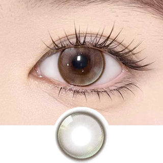 Olala Meow Savannah Brown color contact lens on top of a dark eye paired with subtle eye makeup and curled wispy eyelashes, above the contact lens design.