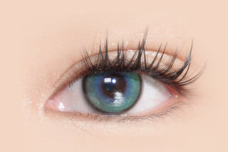 Close-up of dark eyes wearing EyeCandys Powerglow Green contact lens — vibrant green color with full-coverage pigmentation, defined iris from thin limbal ring, UV protection, and moisture-locking MPC polymer. Ideal for bold, dramatic cosplay looks