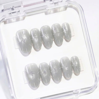 Short almond press on nails Cygnus with icy grey cat eye effect, sharp silver metallic details, and structured minimalist nail design for a modern elegant look.