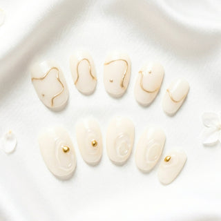 EyeCandys Gilt Lines press on nails featuring sculpted 3D white texture and refined gold accents in a high fashion architectural nail design.