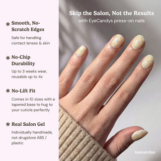 Close up hand showcasing Eyecandys Sweet Disposition press on nails with retro striped pattern and soft pastel polka dot design.