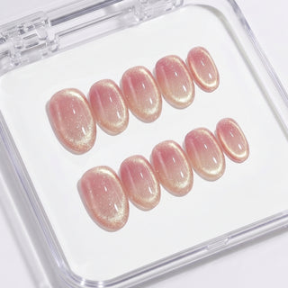 Close-up of EyeCandys Grapefruit Soda press on nails featuring a semi-sheer cat-eye design with soft grapefruit pink gradient, light translucent base, and subtle shimmer on a white background.