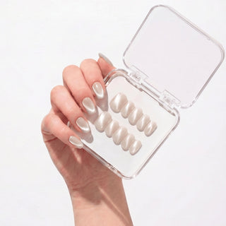 Hand wearing EyeCandys Moon Syrup press on nails with semi-sheer jelly nude base and soft pearly cat-eye glow.