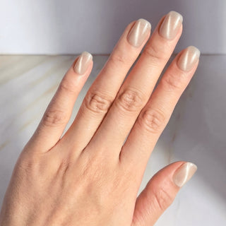 Hand showcasing EyeCandys Moon Syrup press on nails with glossy jelly nude finish and subtle moonlight sheen.